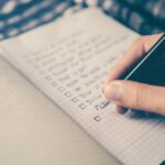 AI Planning - person writing bucket list on book