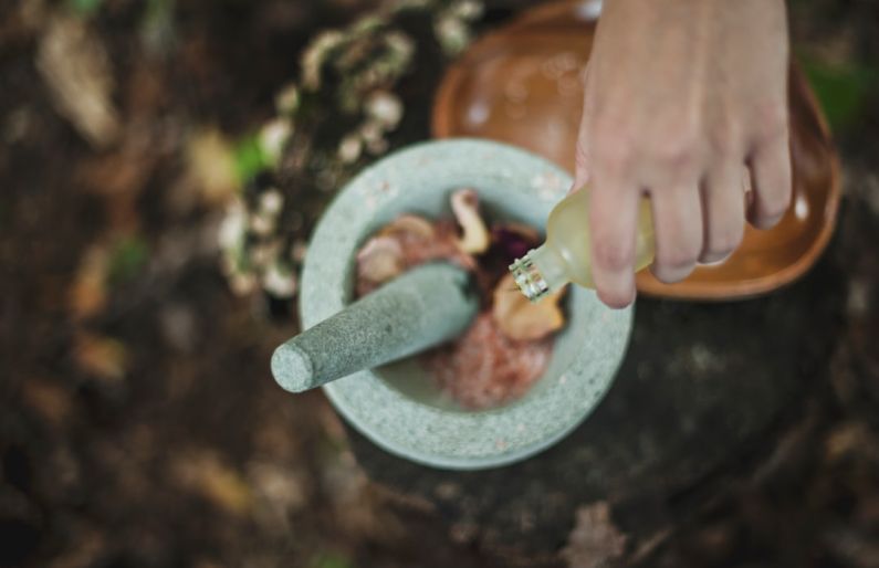 Self-healing Materials - high angle photo of person pouring liquid from bottle inside mortar and pestle